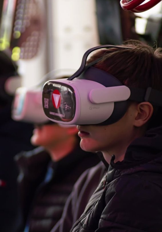 Kind mit VR-Brille taucht in eine virtuelle Welt ein, bunte Reflexionen auf dem Headset – Event-Fotografie WOLF[F]OTO